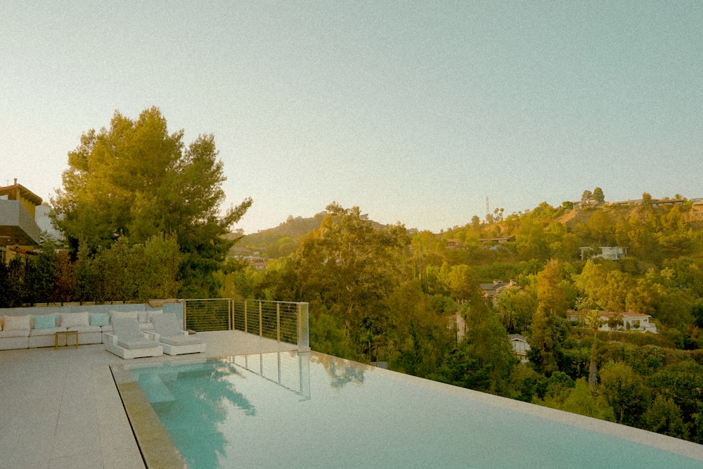 a large swimming pool surrounded by lush green trees