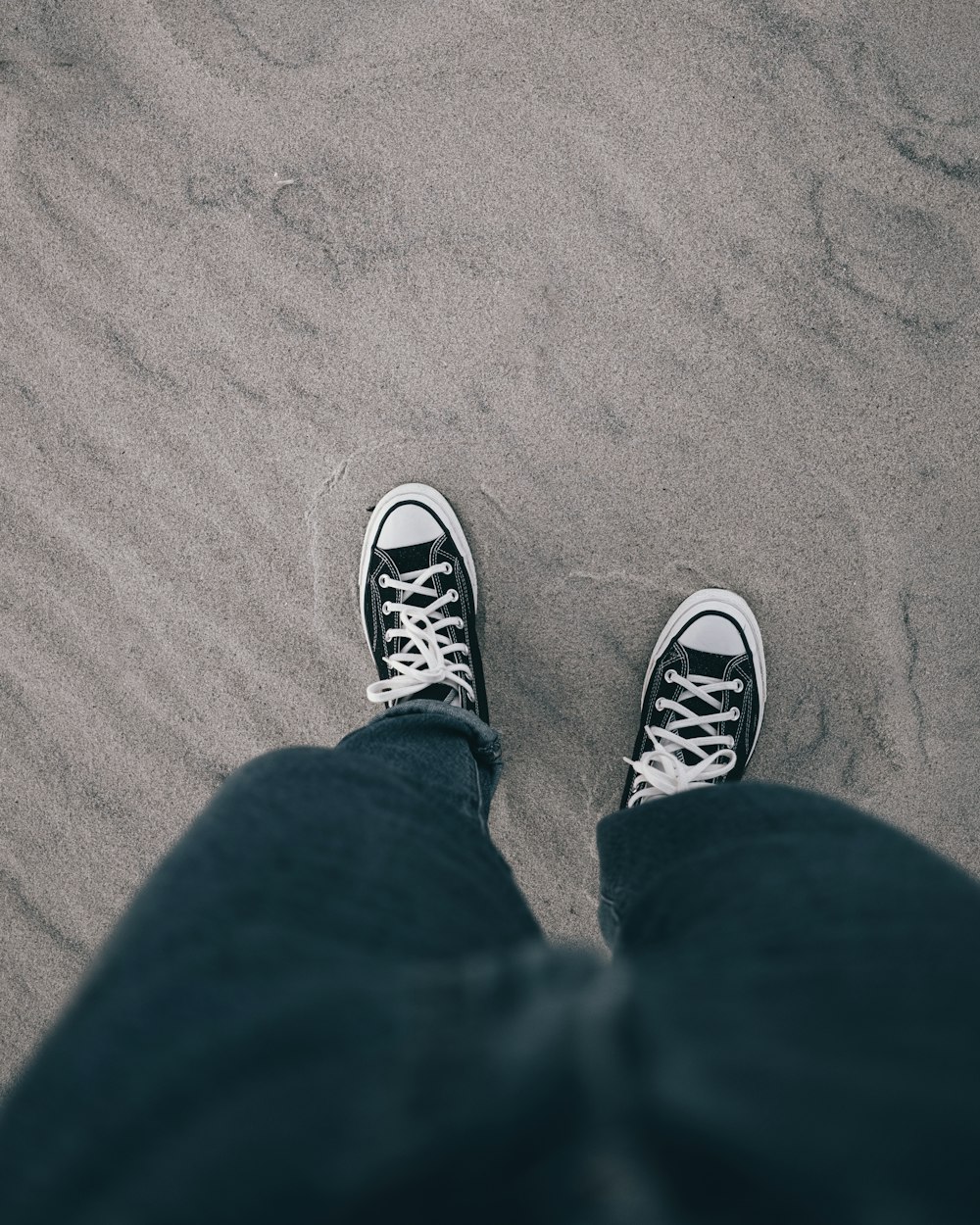 person in blue denim jeans and black and white sneakers