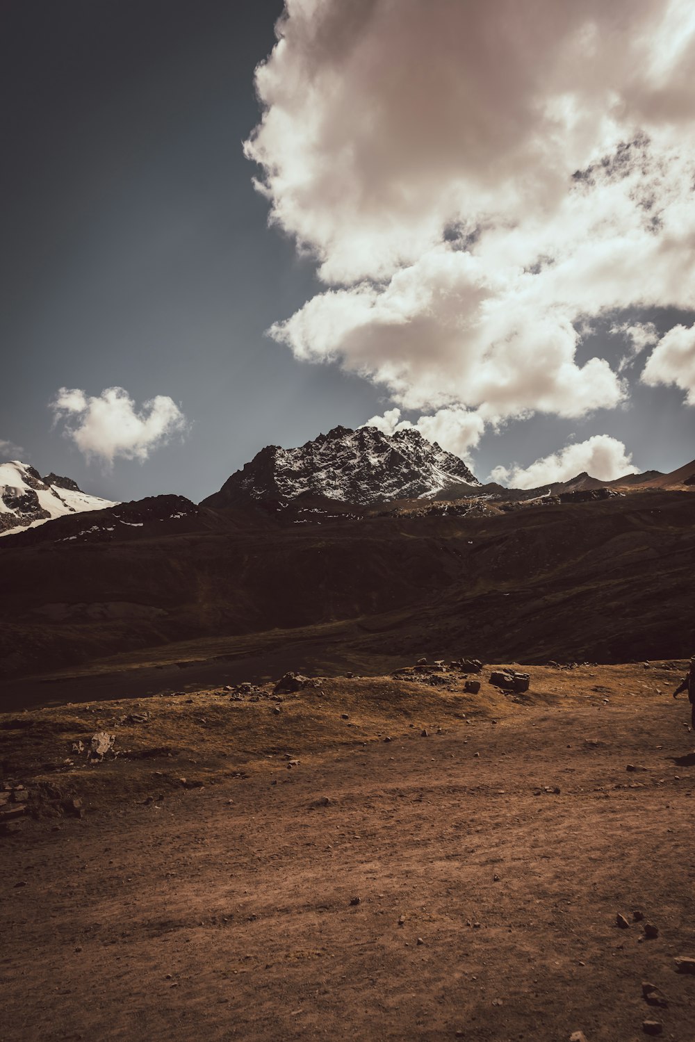 brown and white mountains under white clouds and blue sky during daytime