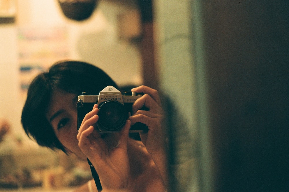 woman holding black and silver camera