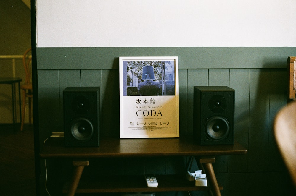 black and gray speaker on brown wooden shelf