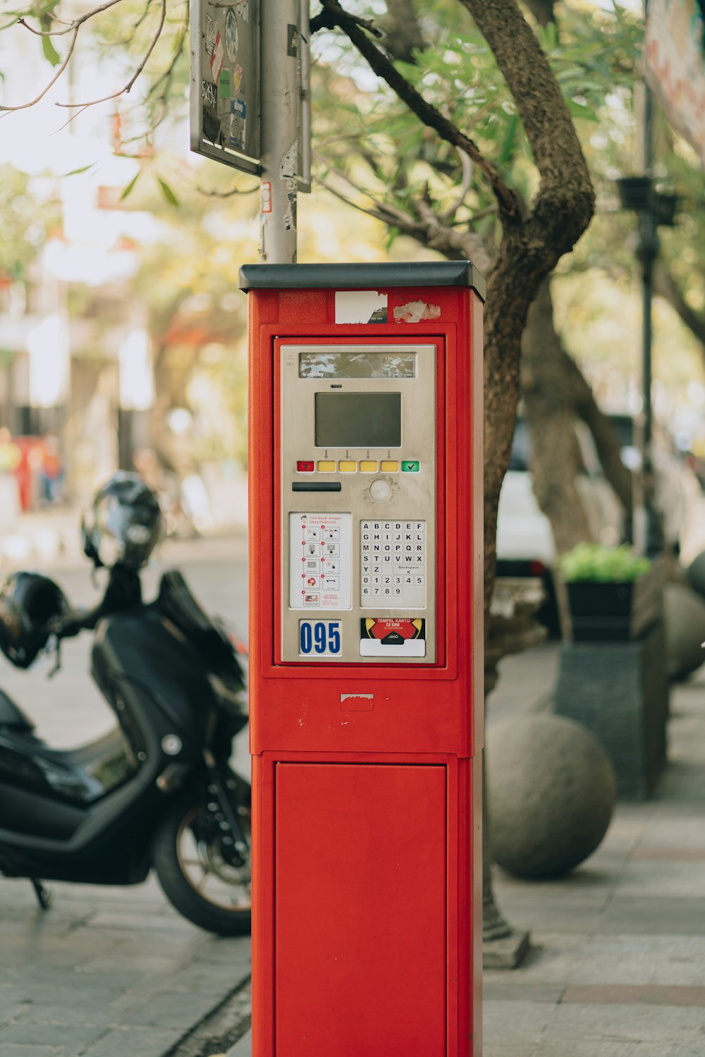 red telephone booth near black motorcycle during daytime