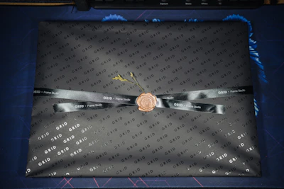 Artisan hands carefully packaging a gold CNC calligraphy frame in protective layers for delivery