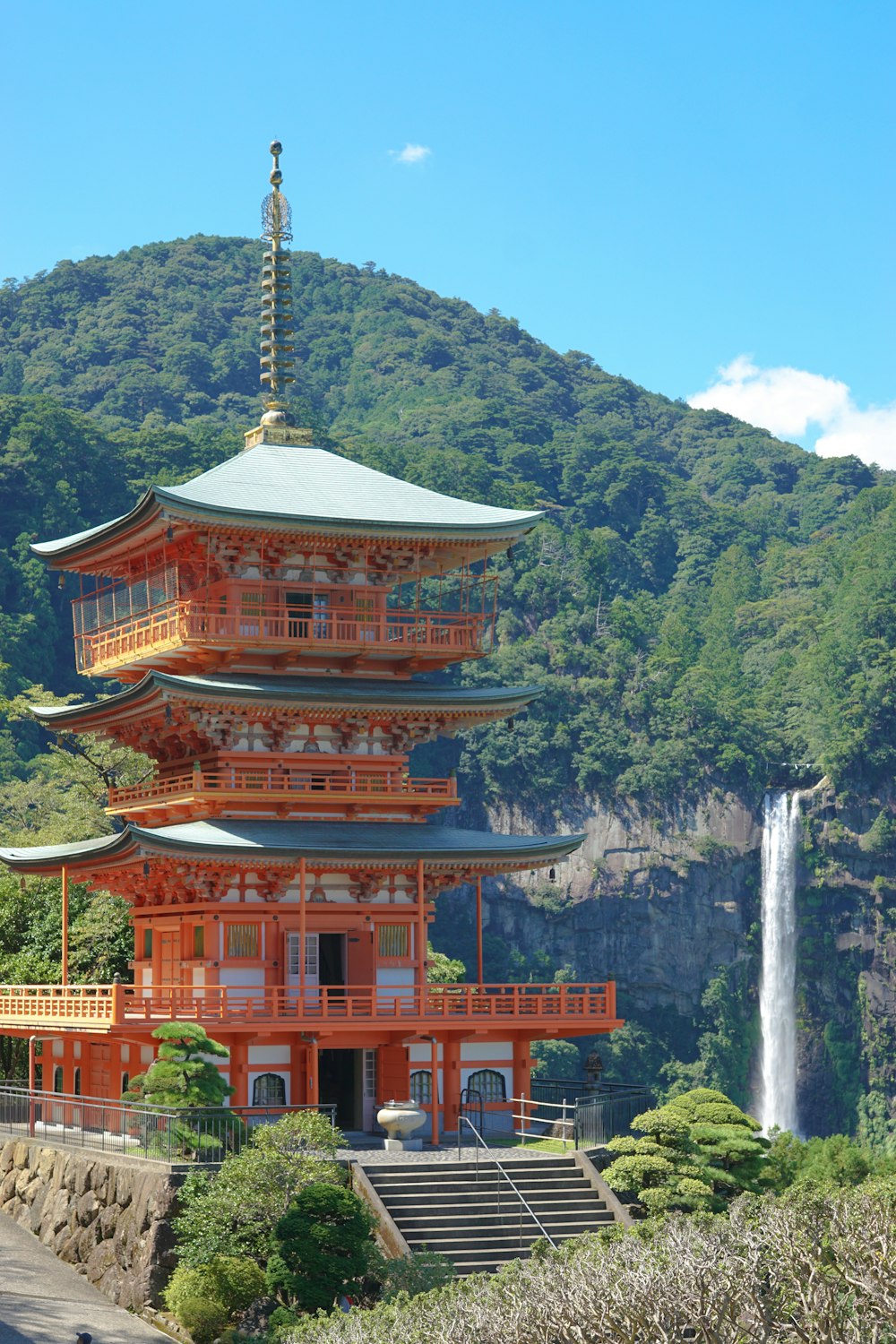 brown wooden pagoda near waterfalls during daytime