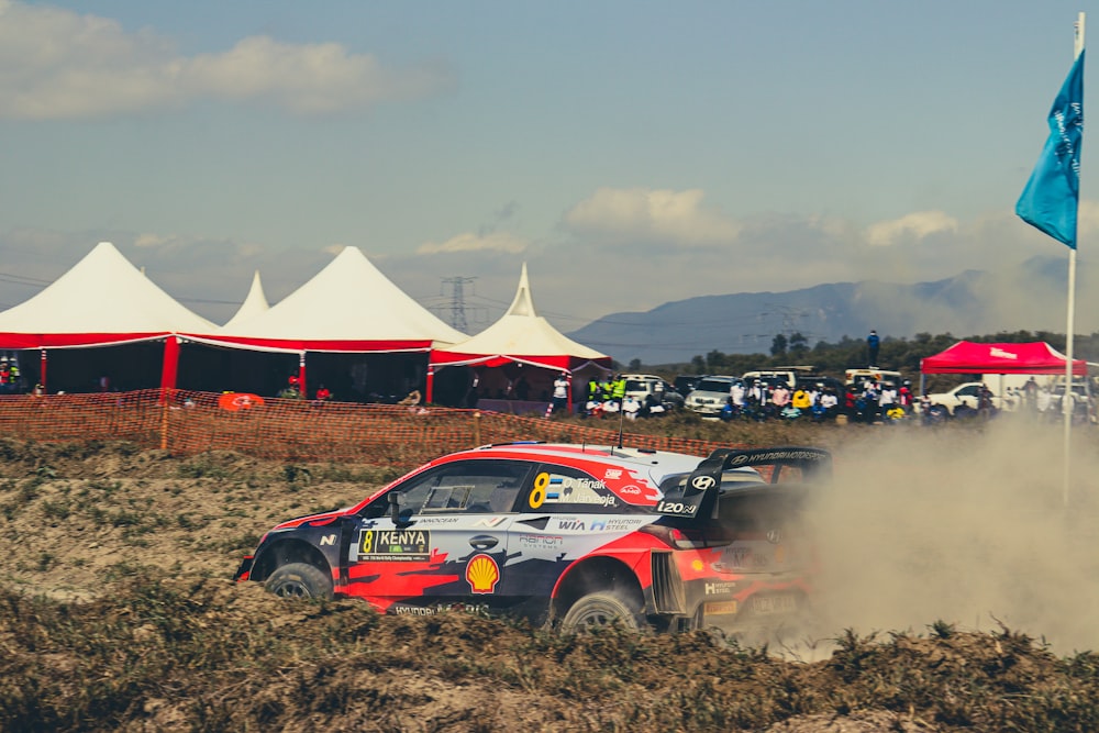 a rally car driving through a dirt field