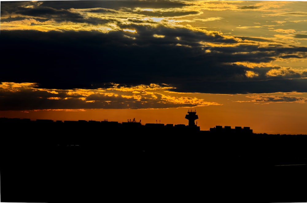 silhouette of people standing on top of building during sunset