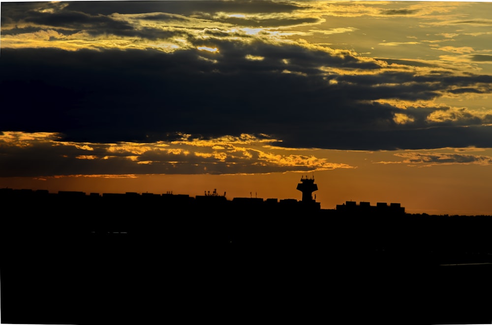 silhouette of people standing on top of building during sunset