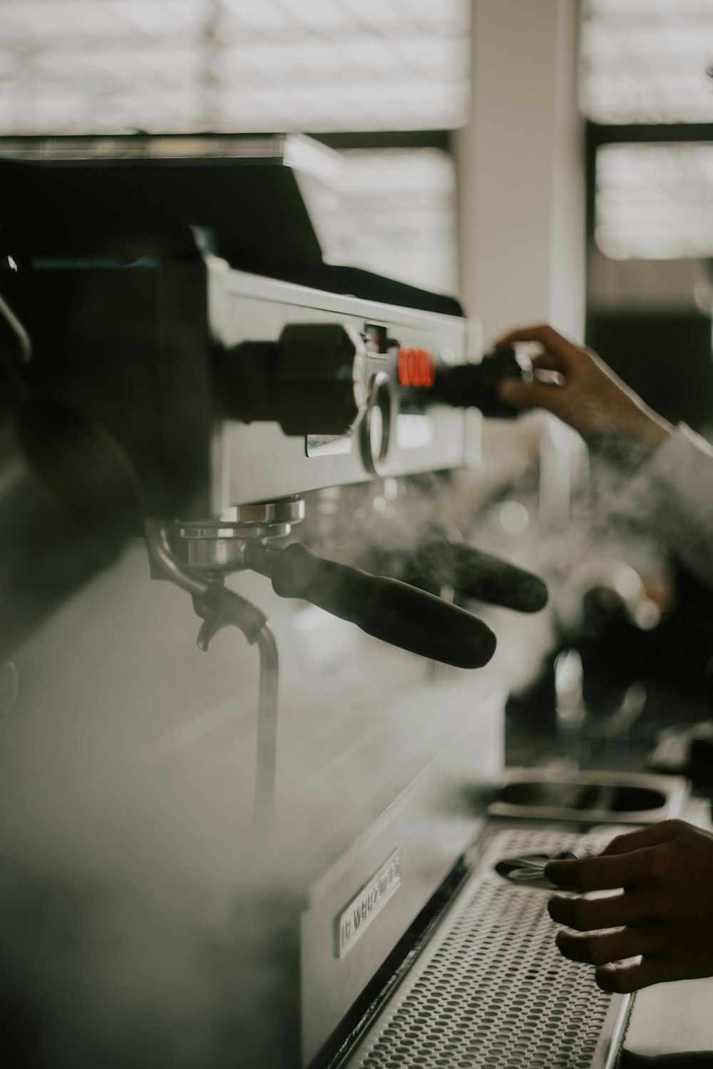 person holding black and silver coffee maker