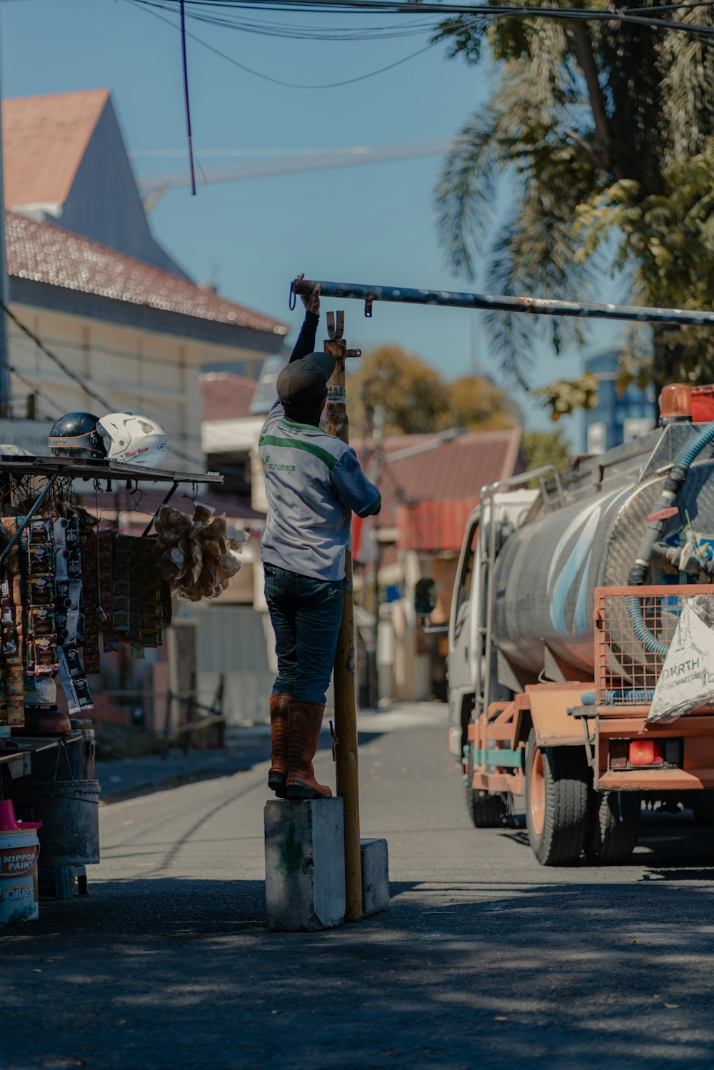 man in blue denim jeans and blue shirt standing near brown truck during daytime