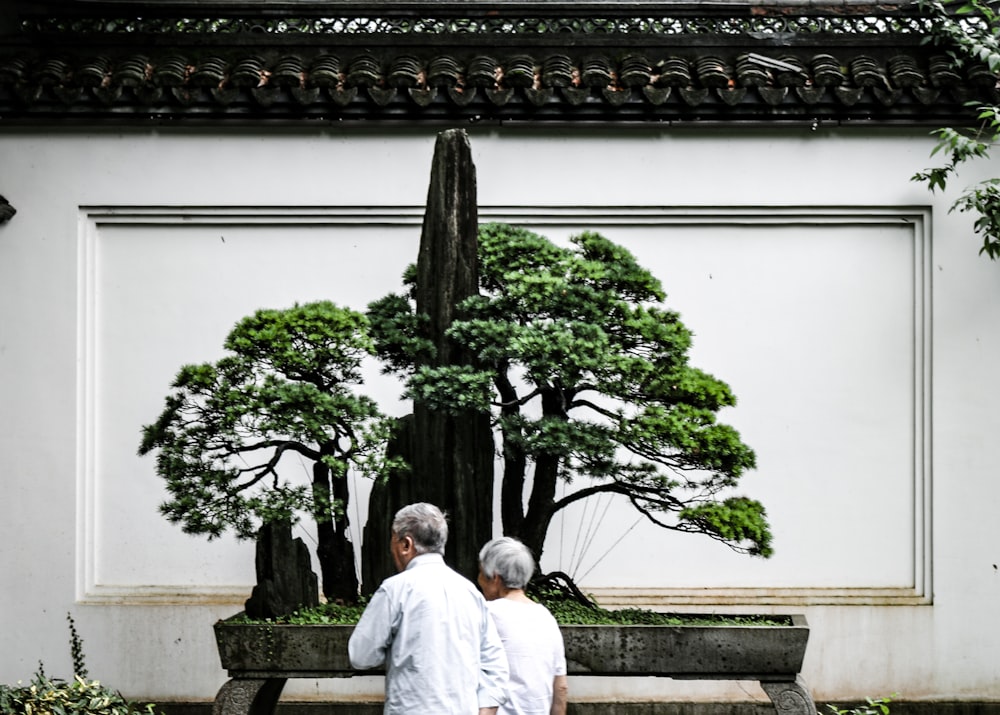 man in white thobe sitting on white concrete bench