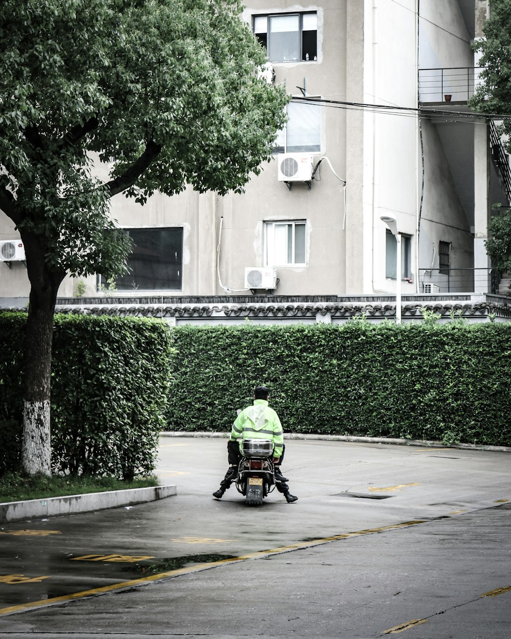 man in green shirt riding motorcycle on road during daytime