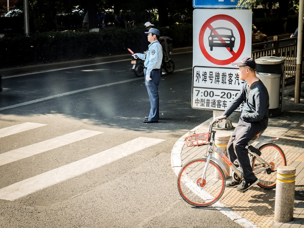 man in black t-shirt riding on bicycle during daytime