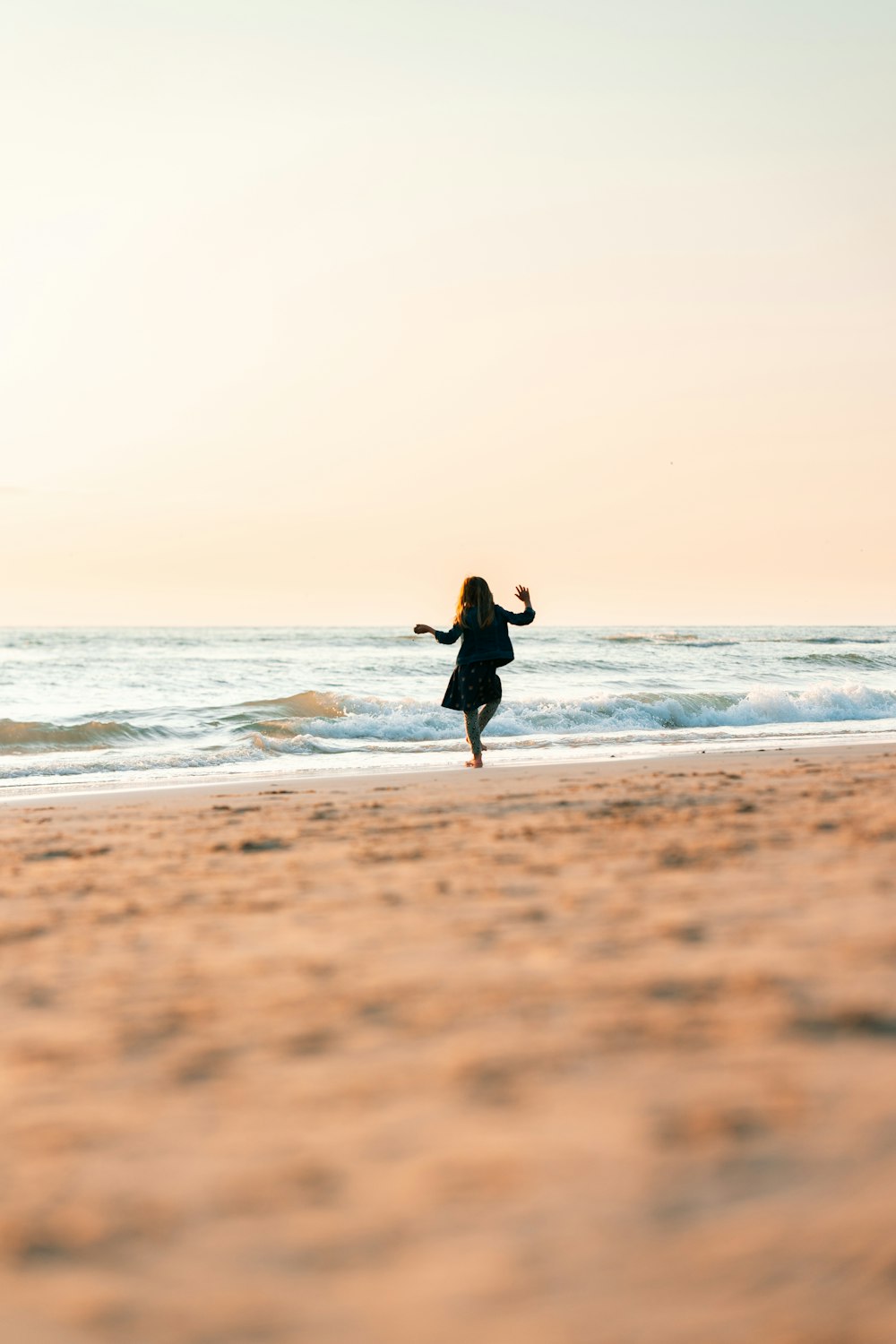 man in black wet suit carrying white surfboard walking on beach during daytime