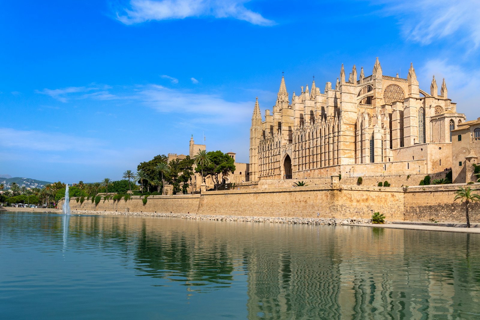 Palma de Mallorca's Gothic cathedral and the Almudaina walls reflected in the lake of the Parc de la Mar