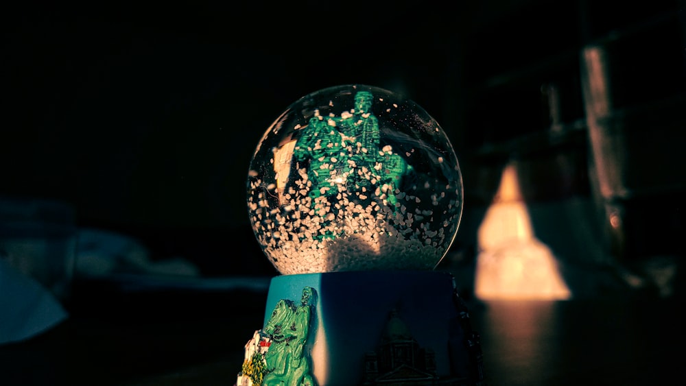 woman in green dress standing in front of clear glass ball