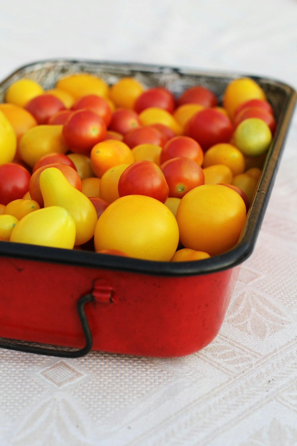 frutas amarelas e vermelhas no recipiente plástico vermelho