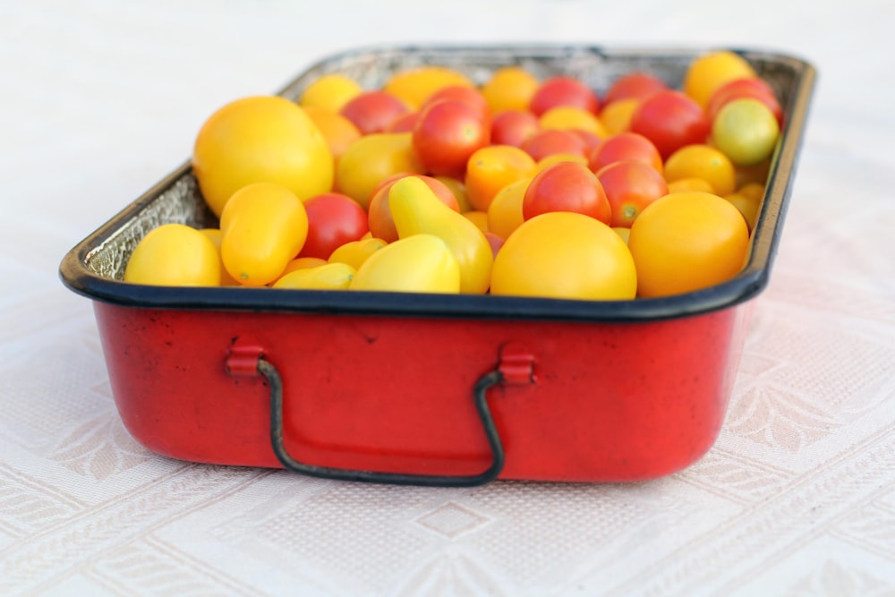 yellow round fruits on red plastic container