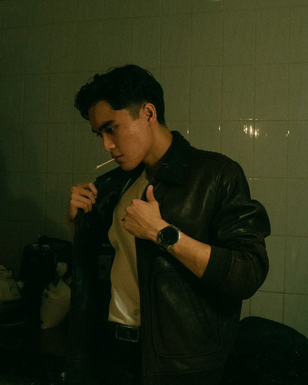 man in black leather jacket smoking cigarette