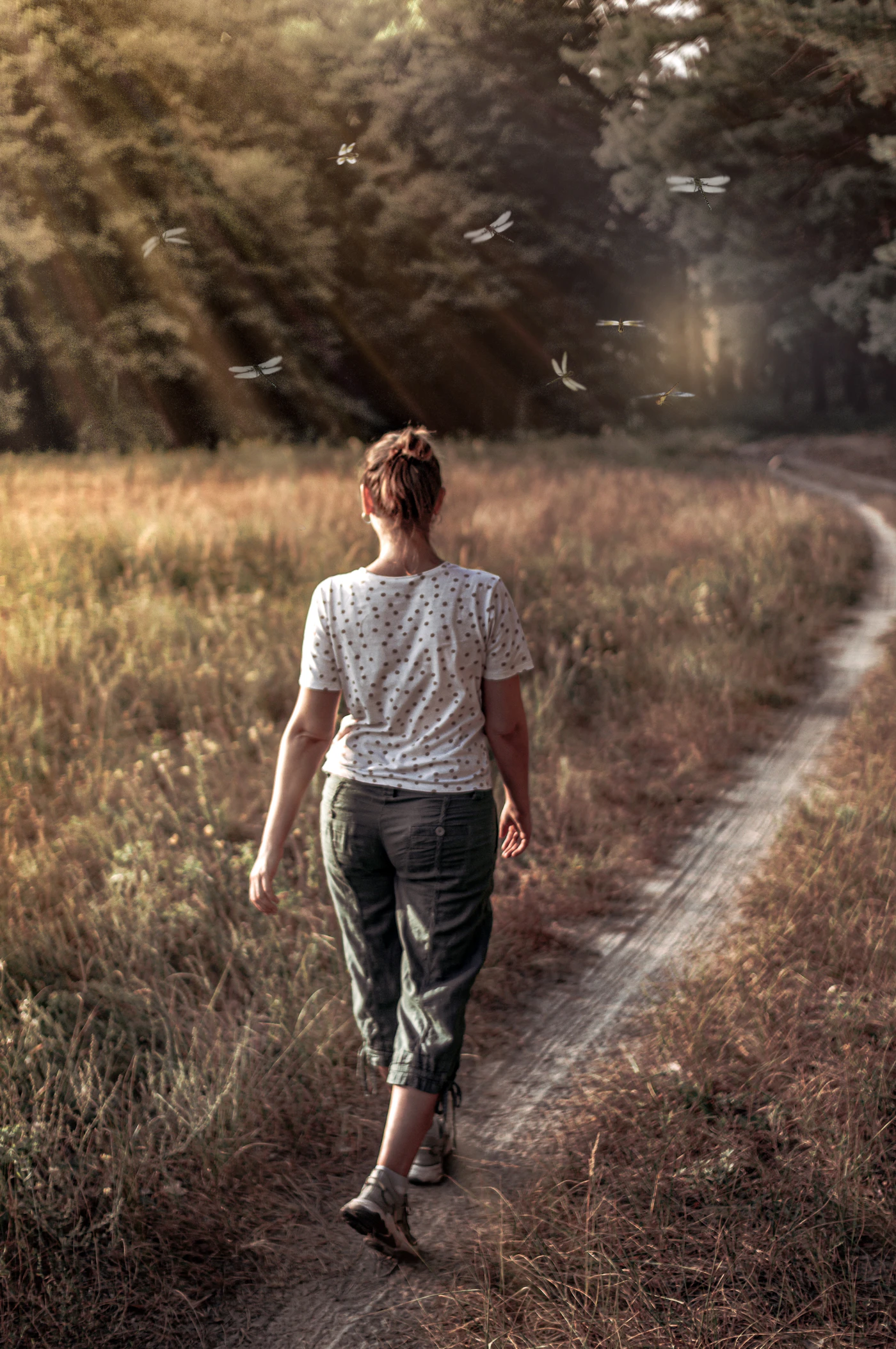 Woman walking along a golden path in natural light