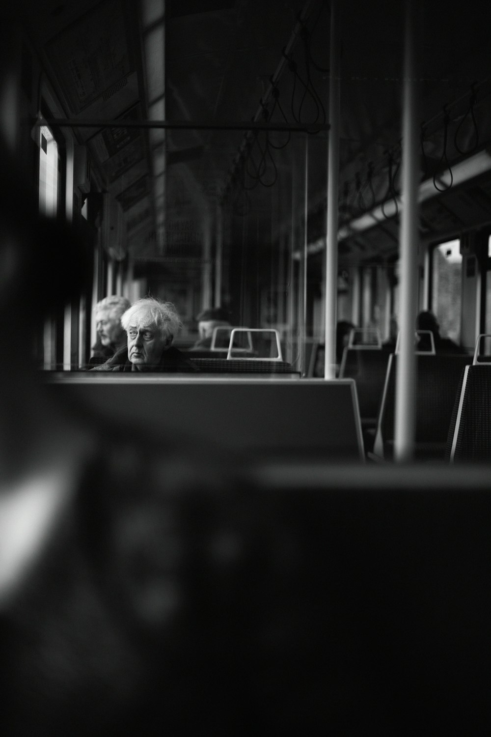 grayscale photo of man in white shirt sitting on chair