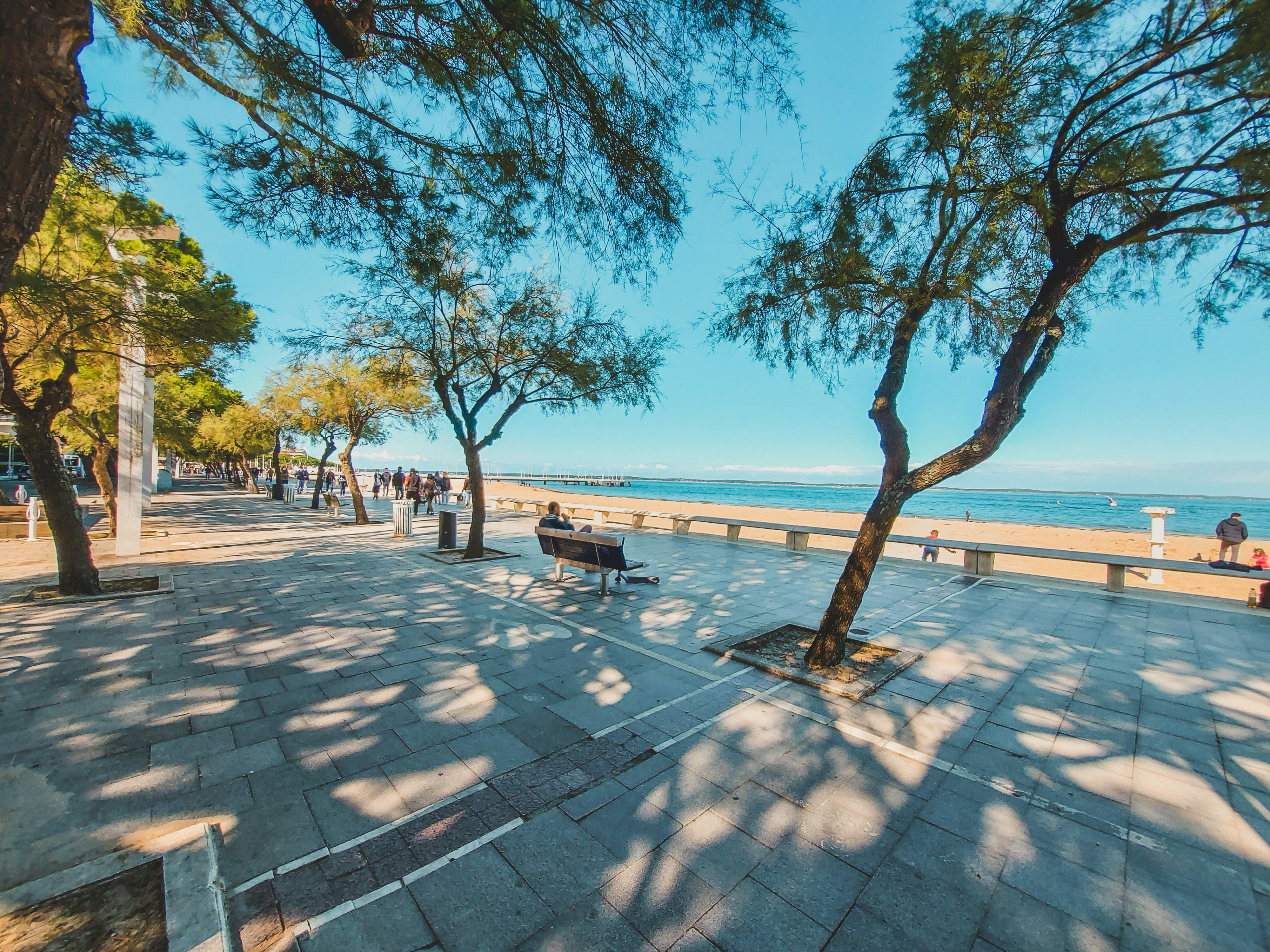 people walking on sidewalk near beach during daytime, Arcachon beach vibes