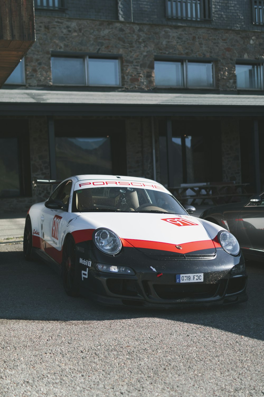 Porsche 911 blanche et rouge sur la route pendant la journée