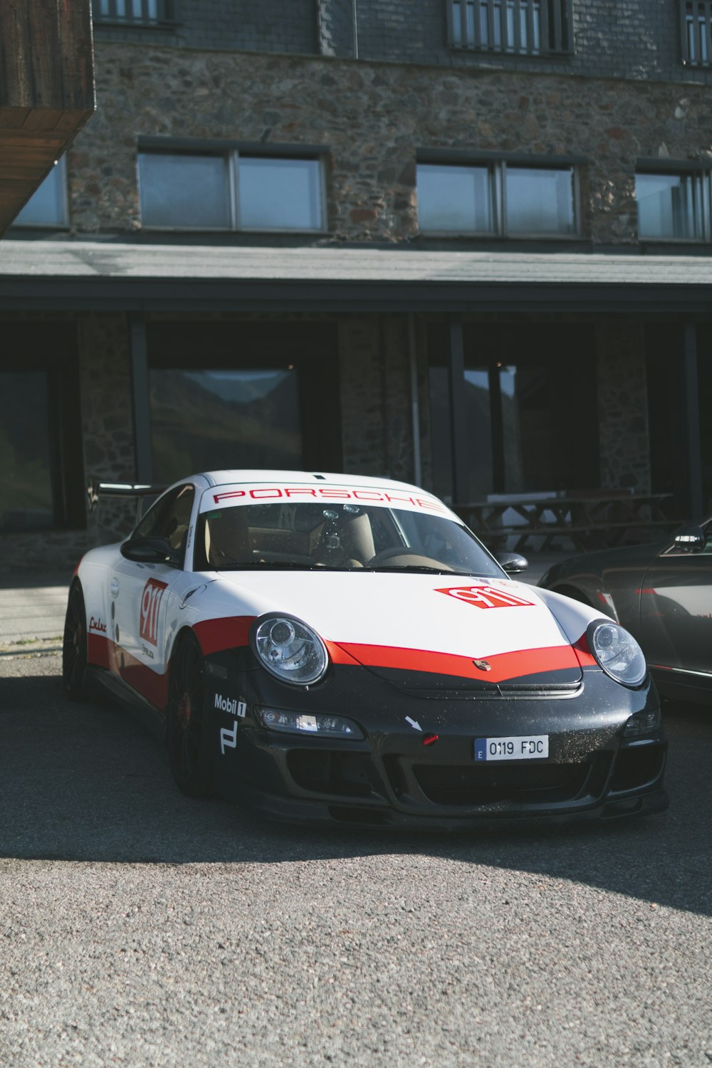 Weiß-roter Porsche 911 tagsüber unterwegs