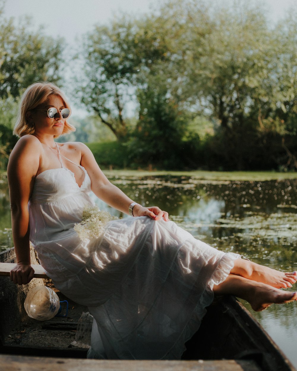 woman in white dress sitting on brown wooden log during daytime