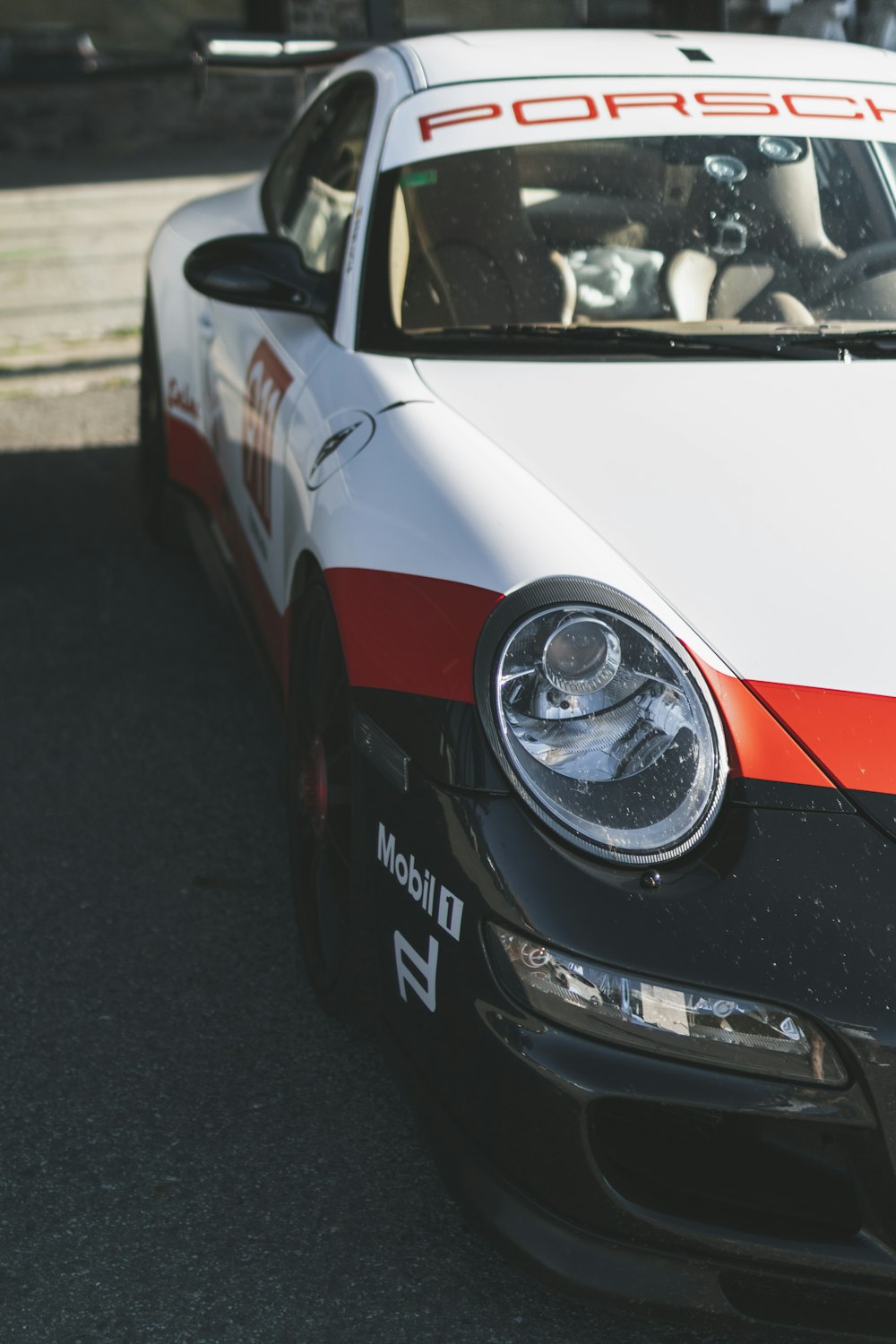 Porsche 911 branco e vermelho na estrada durante o dia