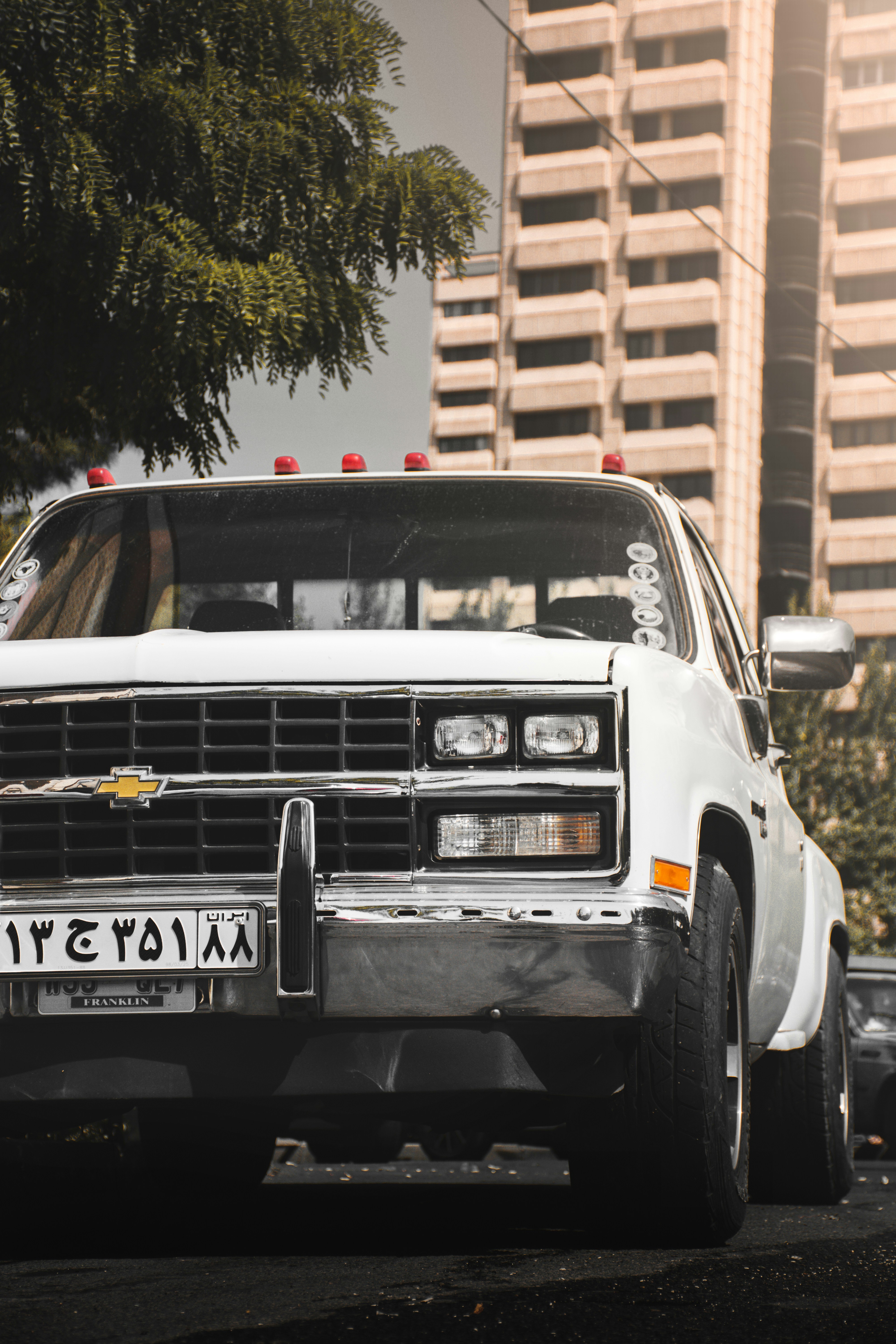 Voiture Mercedes Benz blanche garée près d’un bâtiment brun