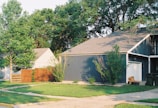 Wide shot of a suburban house with visible security cameras and motion sensors discreetly placed.