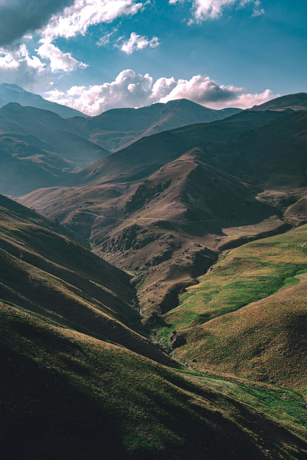 green and brown mountains under white clouds during daytime