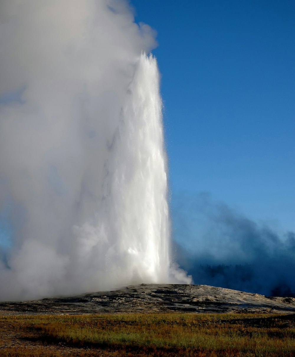 water falls under blue sky during daytime