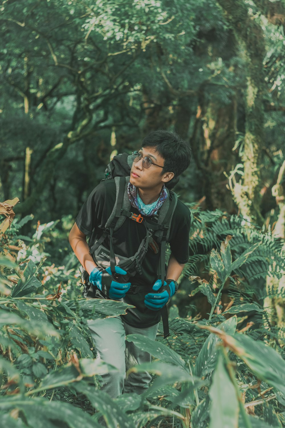 man in black t-shirt and black backpack holding green and black dslr camera