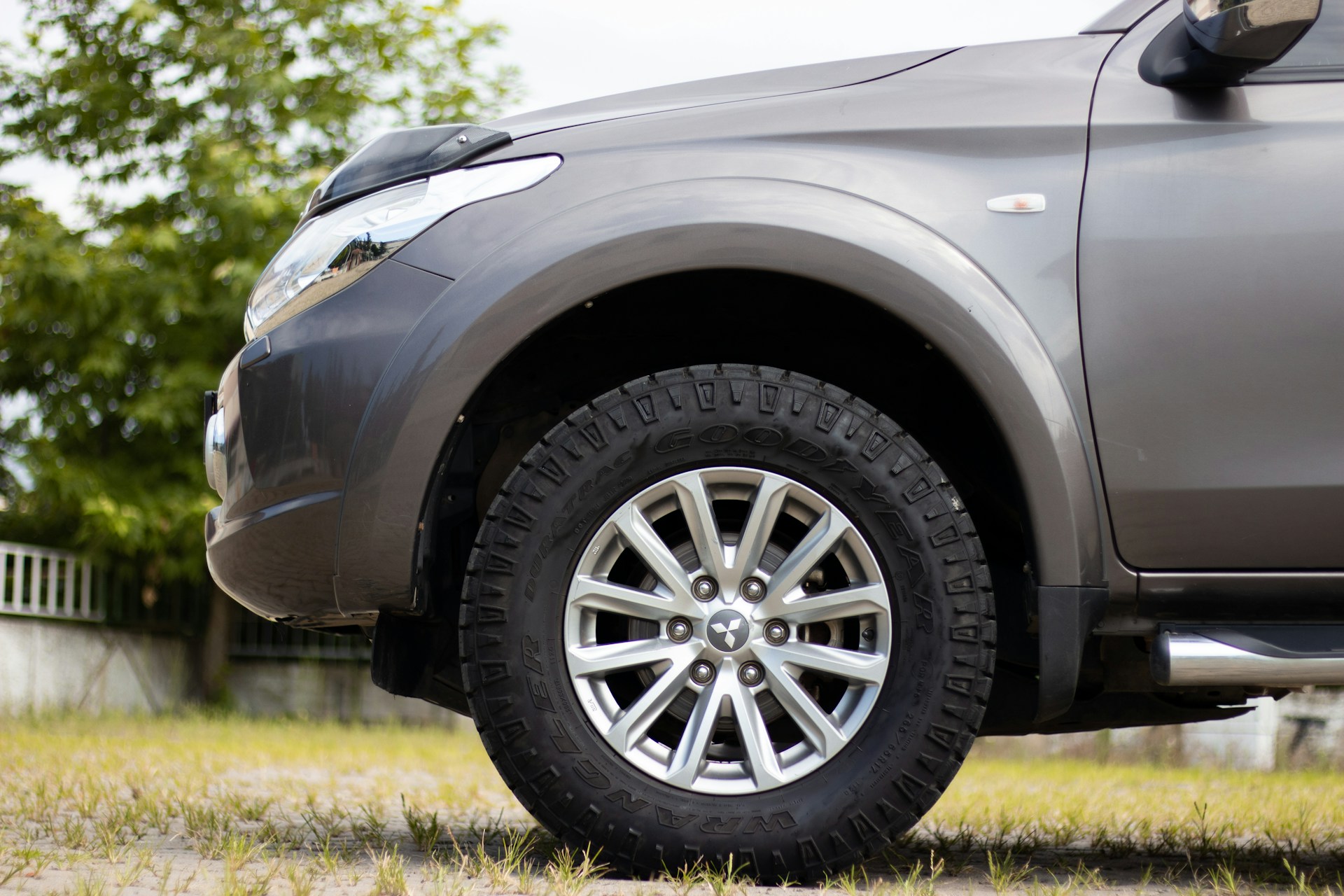 Close-up of a luxury SUV's rugged tire gripping a mountain trail, emphasizing strength and durability.