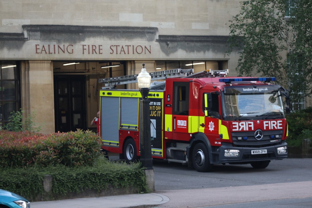 red and yellow fire truck parked near building during daytime