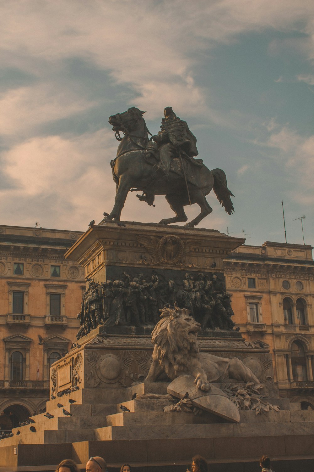 Gente montando estatua de caballo cerca de un edificio de hormigón marrón durante el día