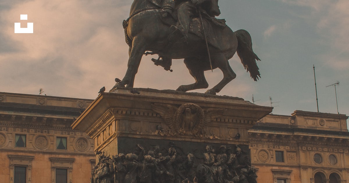 People riding horse statue near brown concrete building during daytime ...