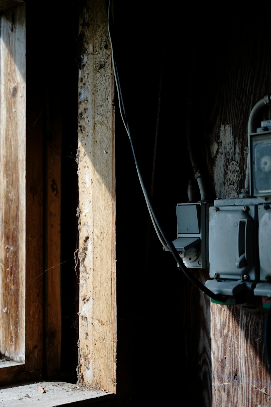 black coated wire on brown wooden wall