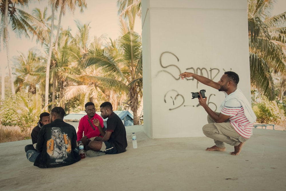 people sitting on floor near palm trees during daytime