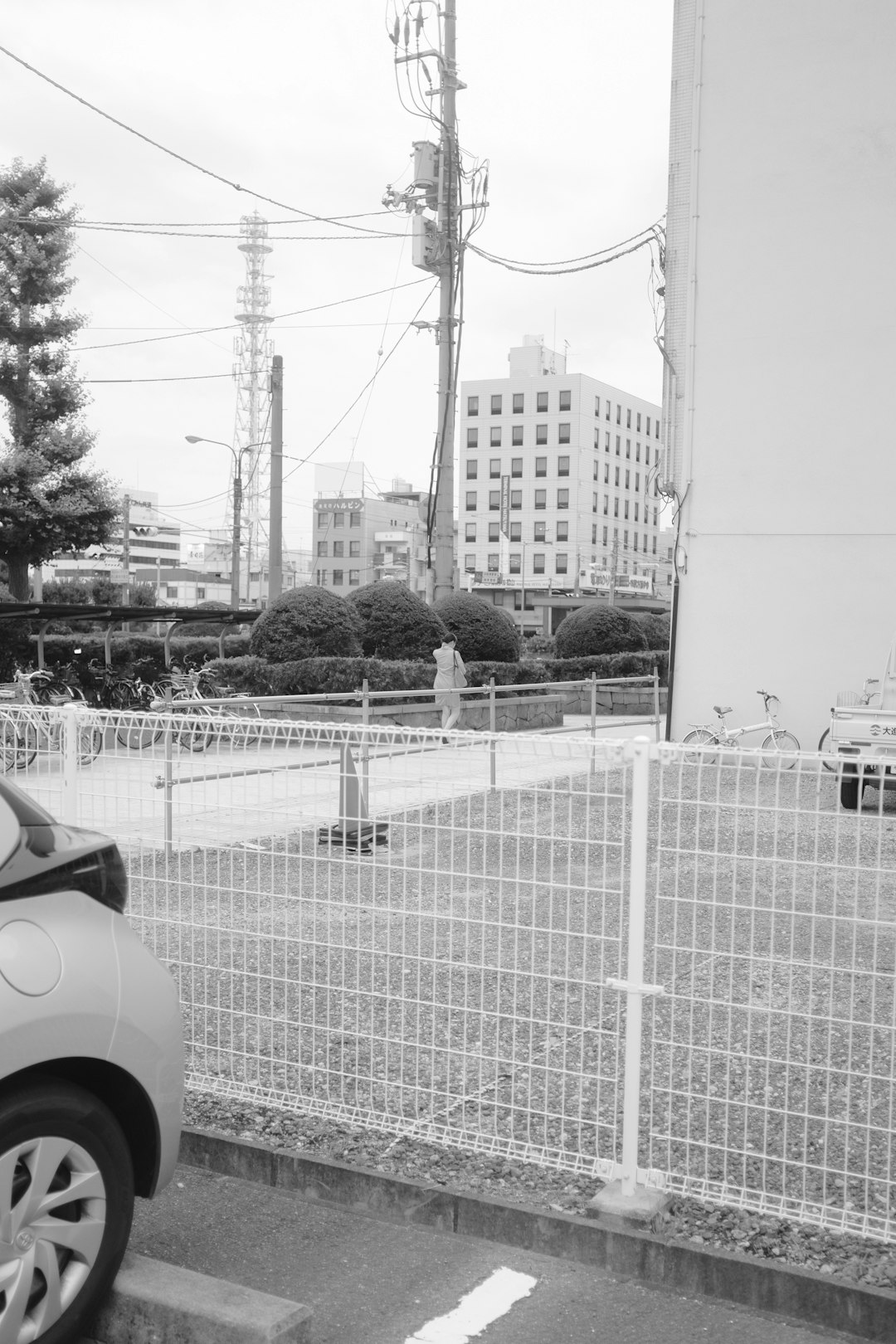 grayscale photo of car parked near fence