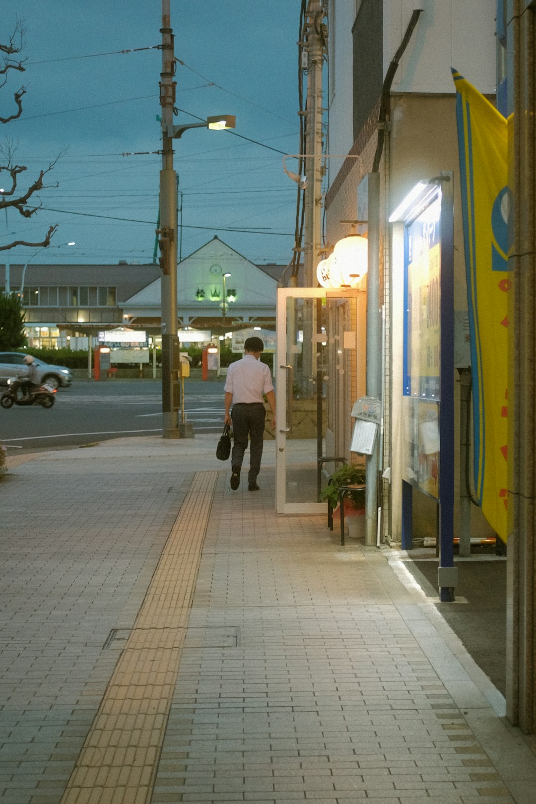 woman in black jacket walking on sidewalk during daytime