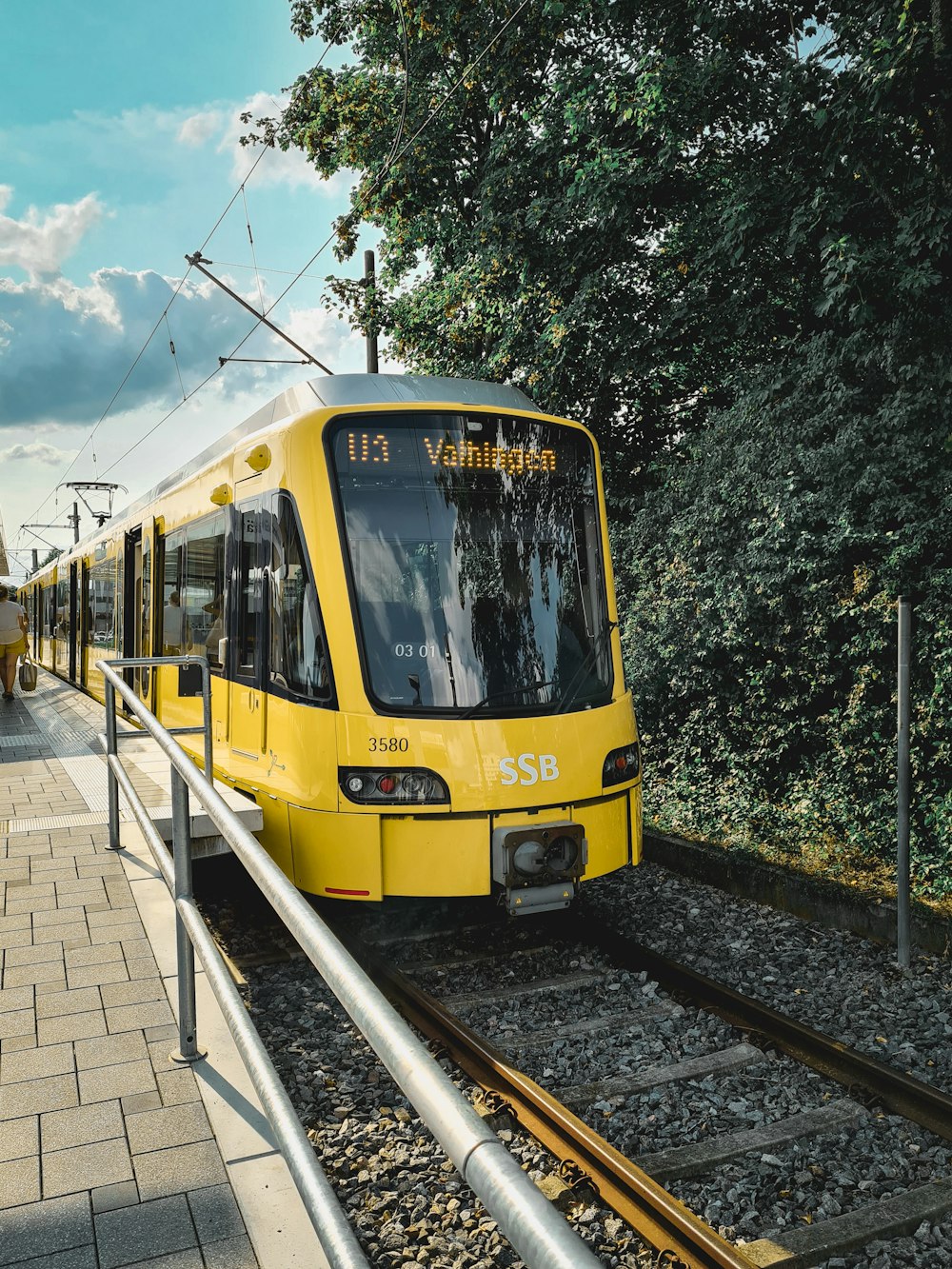 yellow and white tram on rail road during daytime