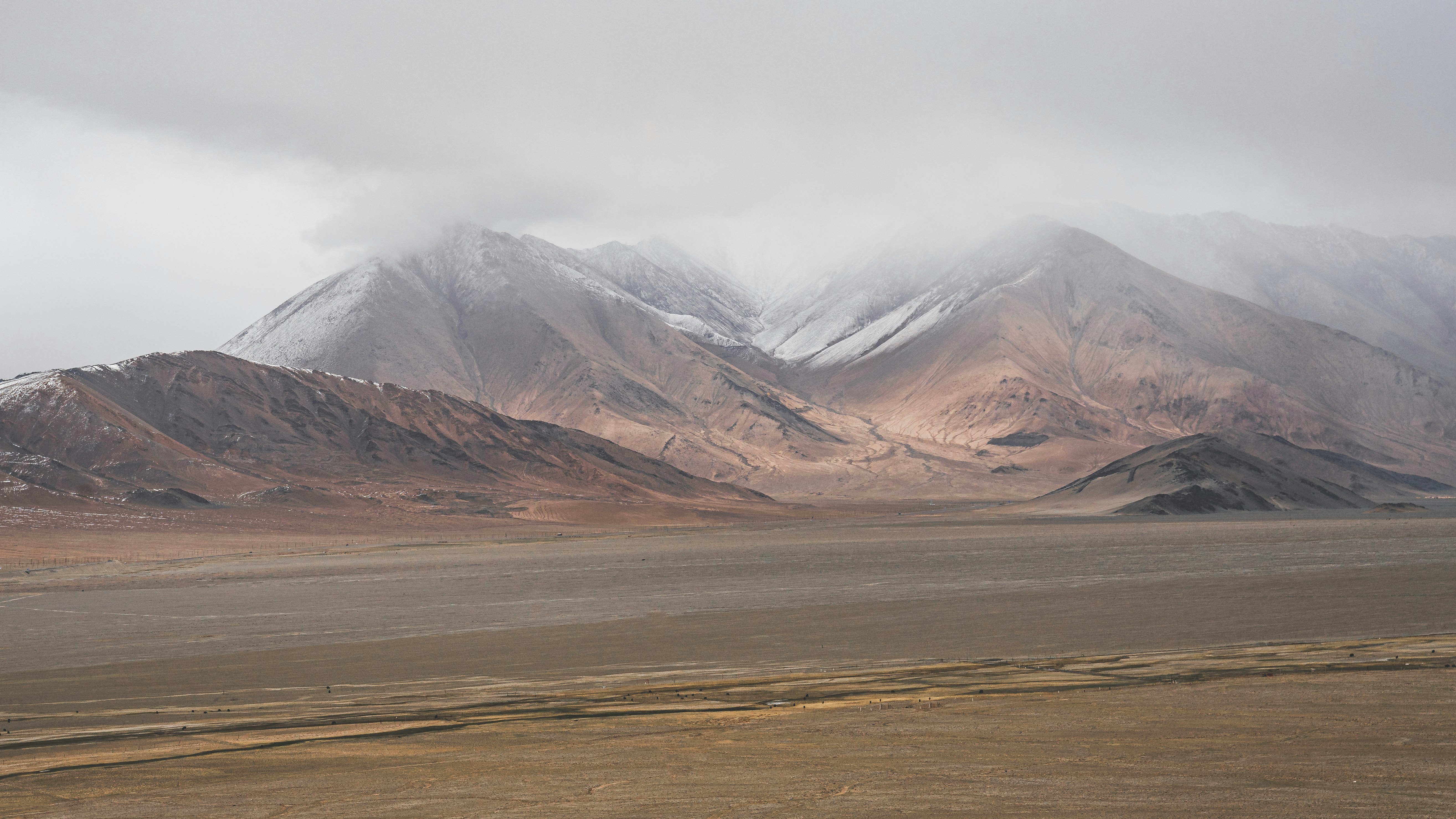 brown and white mountains under white sky during daytime