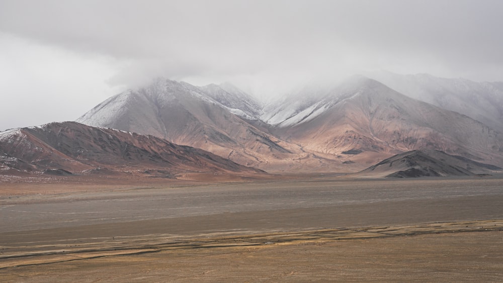 brown and white mountains under white sky during daytime