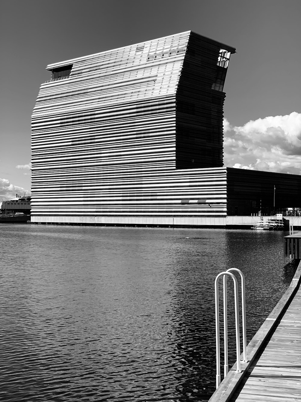 grayscale photo of a building near the sea