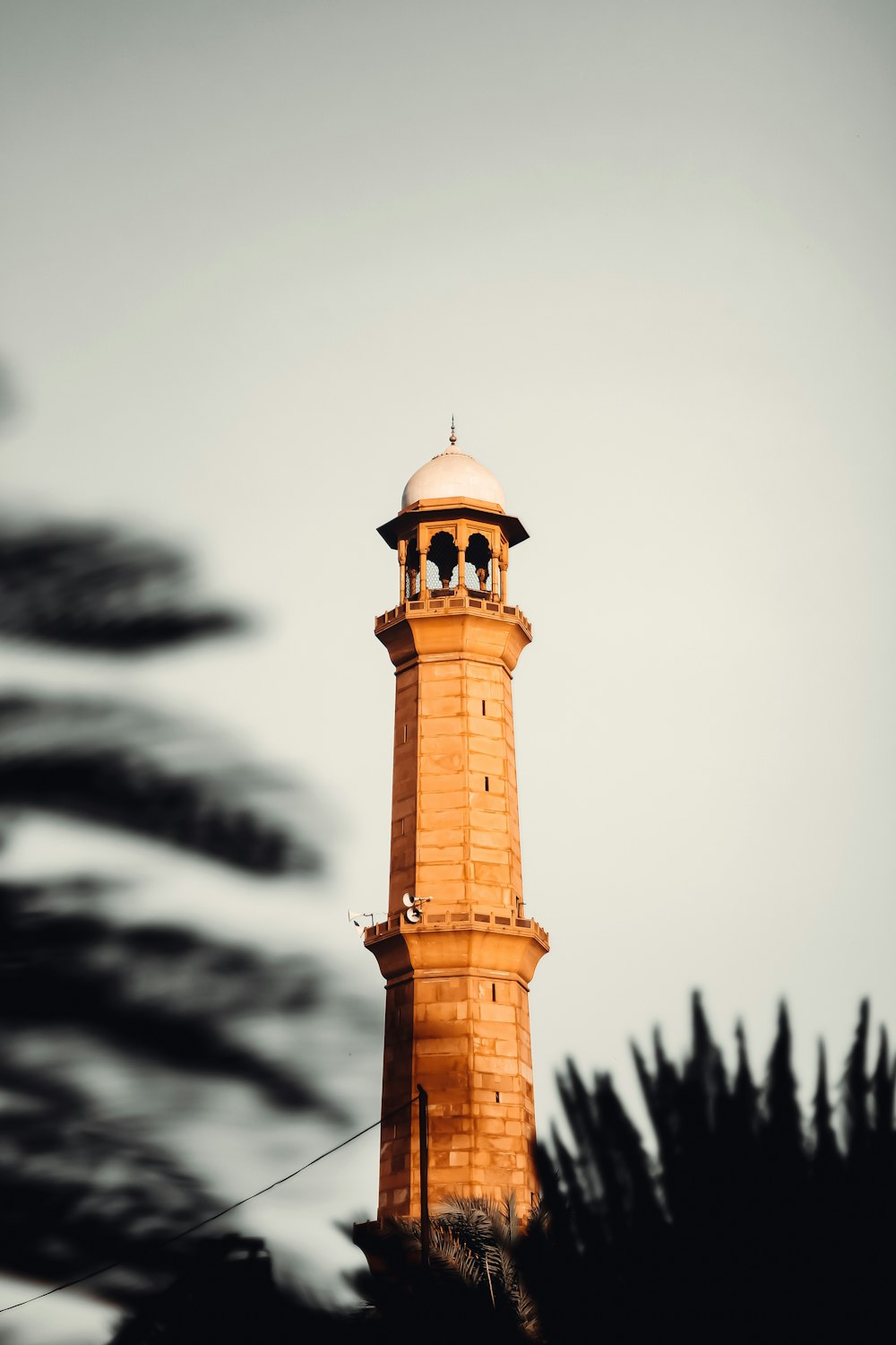 torre di cemento marrone sotto il cielo bianco