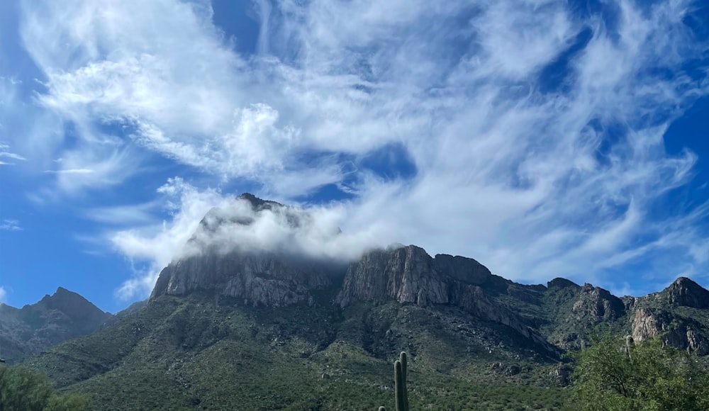 green and gray mountain under blue sky and white clouds during daytime