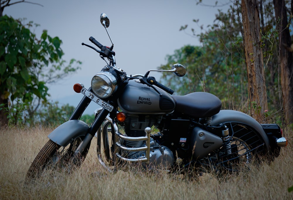 moto cruiser noir et argent sur le terrain d’herbe brune pendant la journée