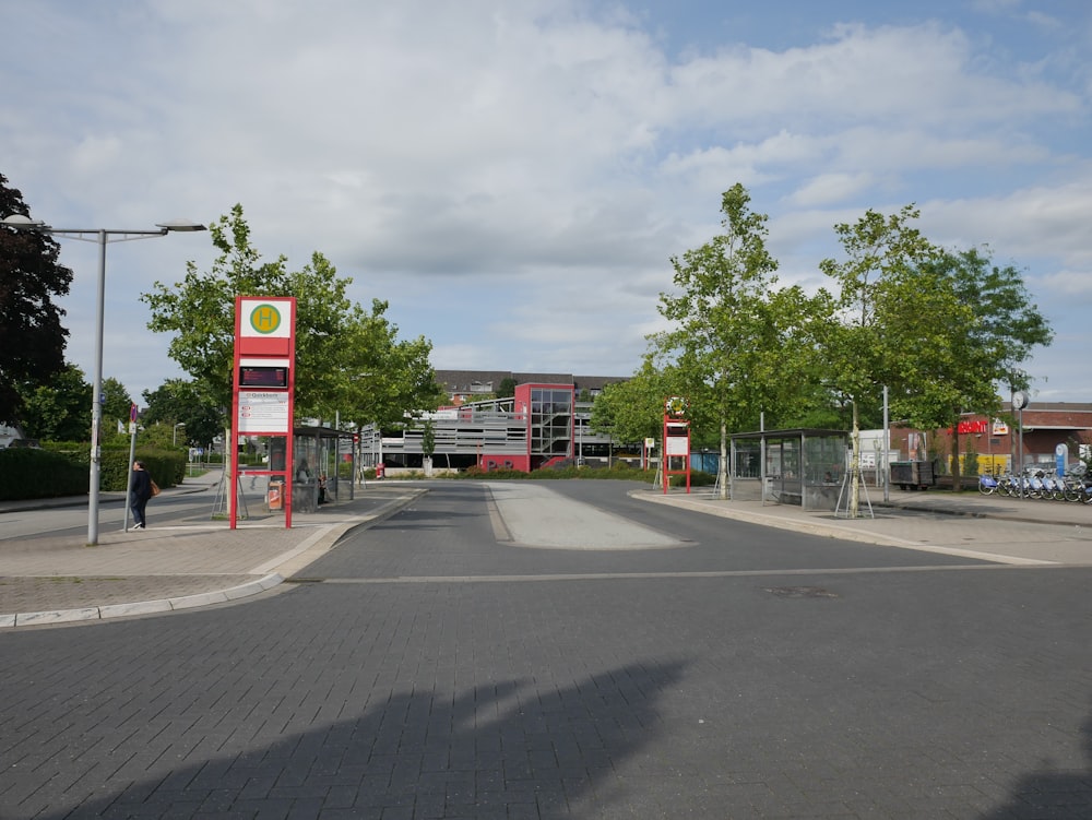 green trees near red and white building